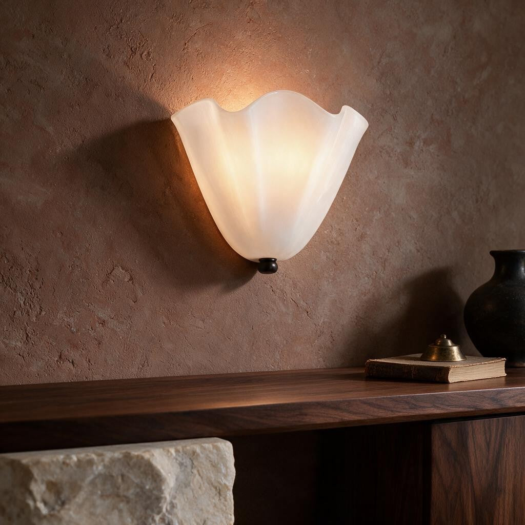 Applique murale en verre blanc ONDA allumée au-dessus d'une console en noyer, contre un mur enduit brun – Ambiance Éclat