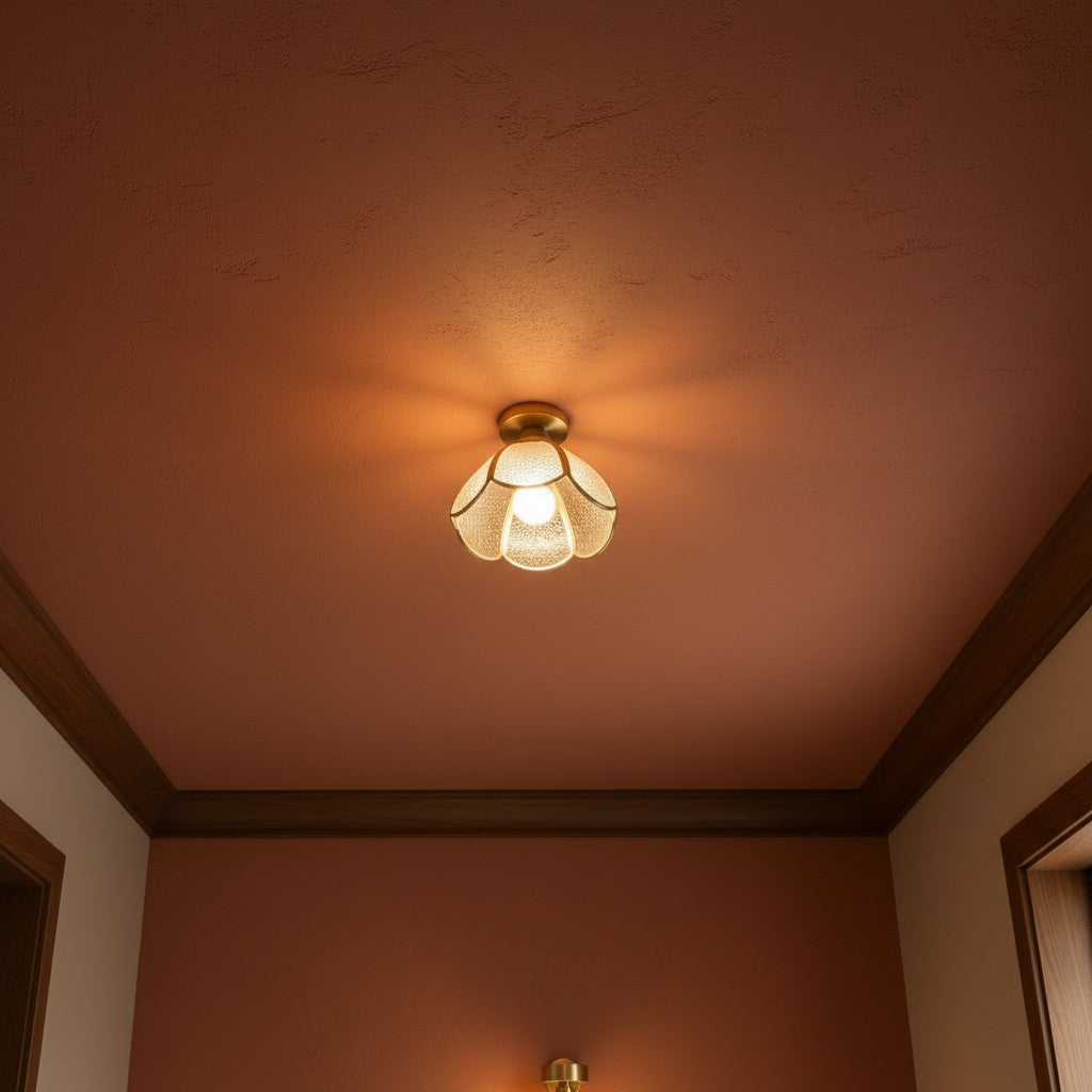 Plafonnier CAPRI en verre ambré, allumé au plafond d'un intérieur aux murs terracotta – Ambiance Éclat