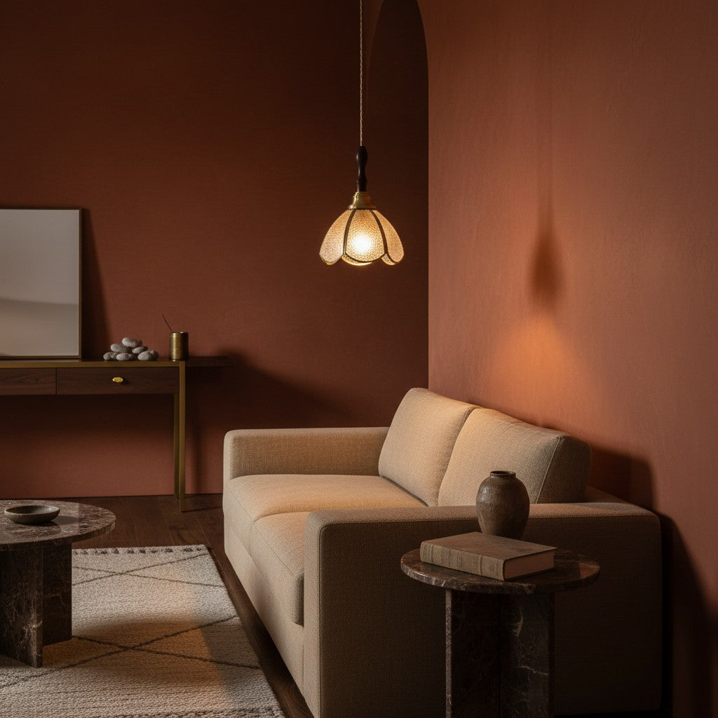 Suspension CAPRI en verre ambré, allumée devant un mur terracotta – Ambiance Éclat