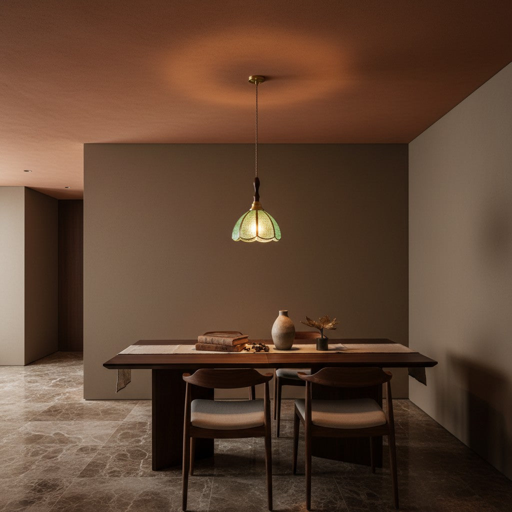Suspension LIPARI en verre vert, allumée au-dessus d'une table dans un intérieur sombre – Ambiance Éclat